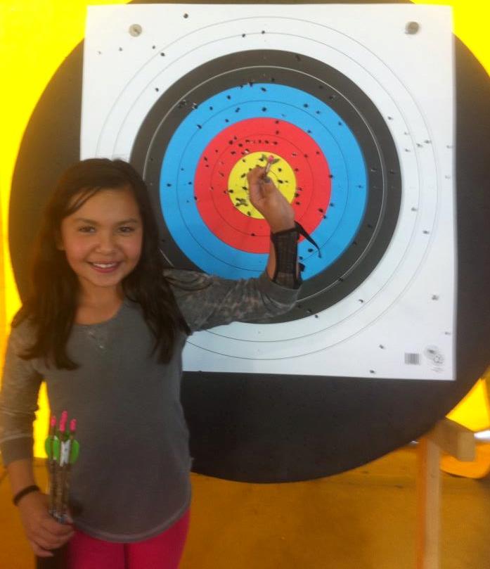 Girl holding arrow on a target